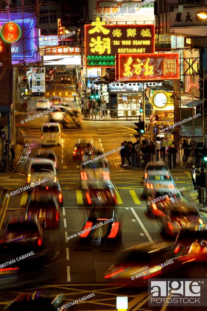 Stock Photo: Busy street at night with cars moving along the street and colorful neon advertisements in chinese letters at Causeway Bay, Hong Kong Island, Hong Kong, China.