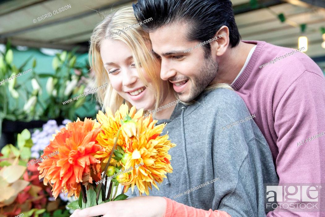 Stock Photo: Man pleases girlfiend with surprise gift of flowers.