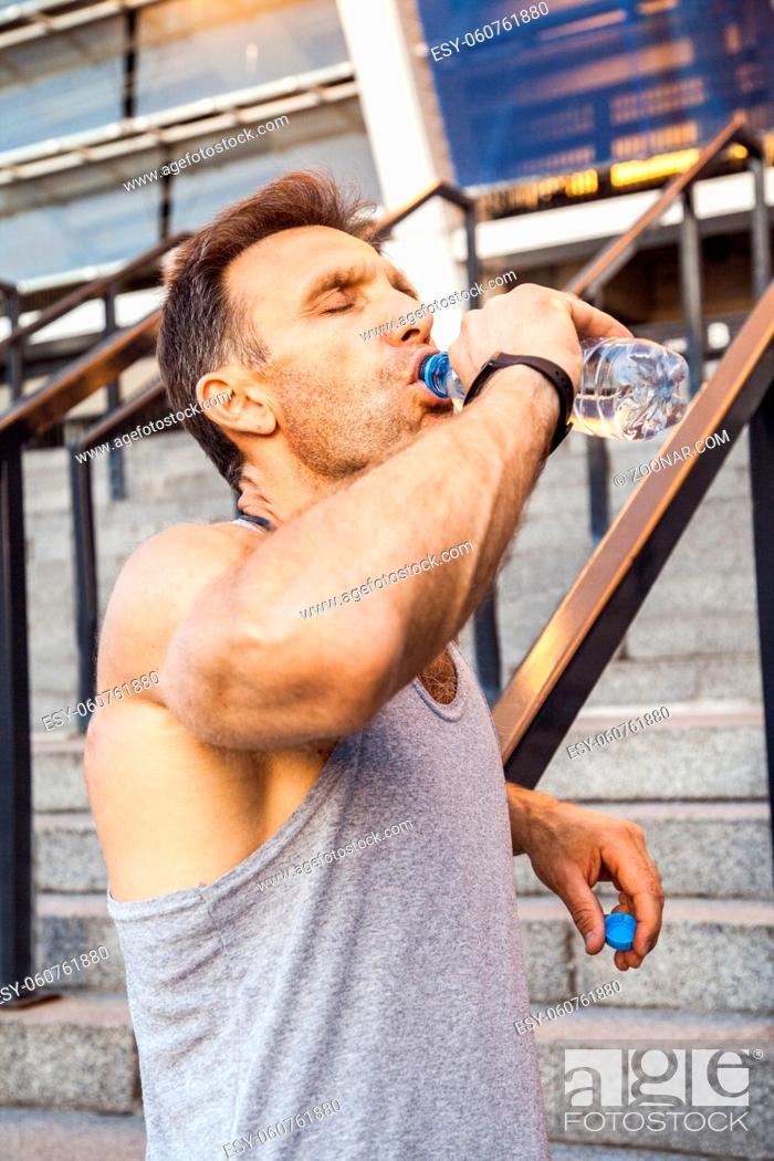 Stock Photo: Thirsty sportsman take a rest and drinking water after running. fitness, sport, exercising and people healthy lifestyle concept.
