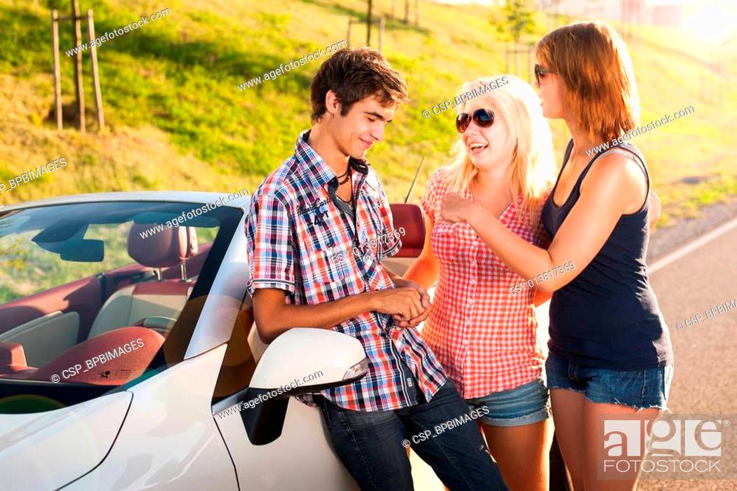 Stock Photo: three young traveler beside a car.