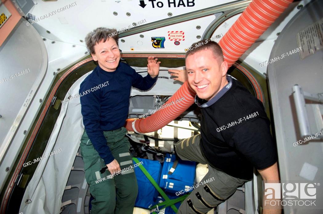 Stock Photo: NASA astronauts Peggy Whitson and Jack Fischer are pictured packing up gear inside the International Space Station.