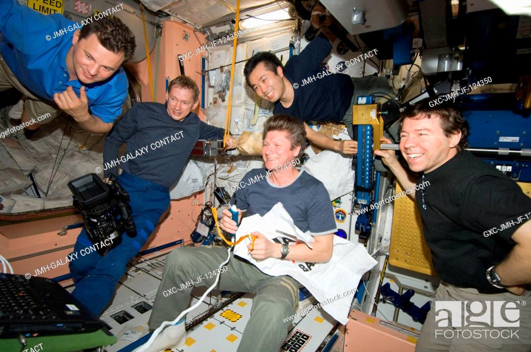 Stock Photo: Expedition 20 crew members view a monitor in the International Space Station's Unity node as they celebrate Father's Day and the birthday of cosmonaut Gennady.