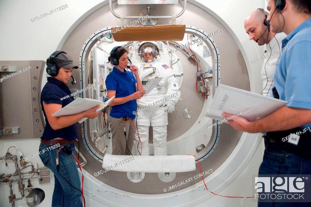 Stock Photo: NASA astronaut Alvin Drew, STS-133 mission specialist, participates in an Extravehicular Mobility Unit (EMU) spacesuit fit check in the Space Station Airlock.