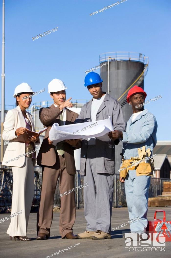 Photo de stock: Multi-ethnic businesspeople and construction workers looking at blueprints.