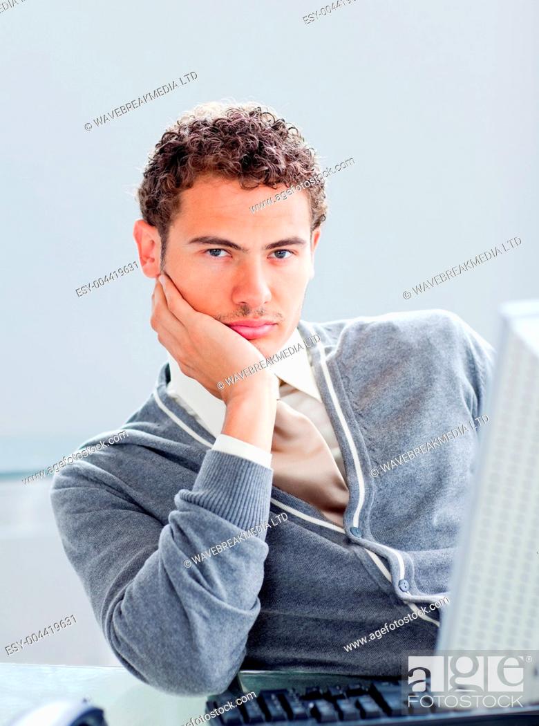 Stock Photo: Portrait of a young businessman getting bored at work.