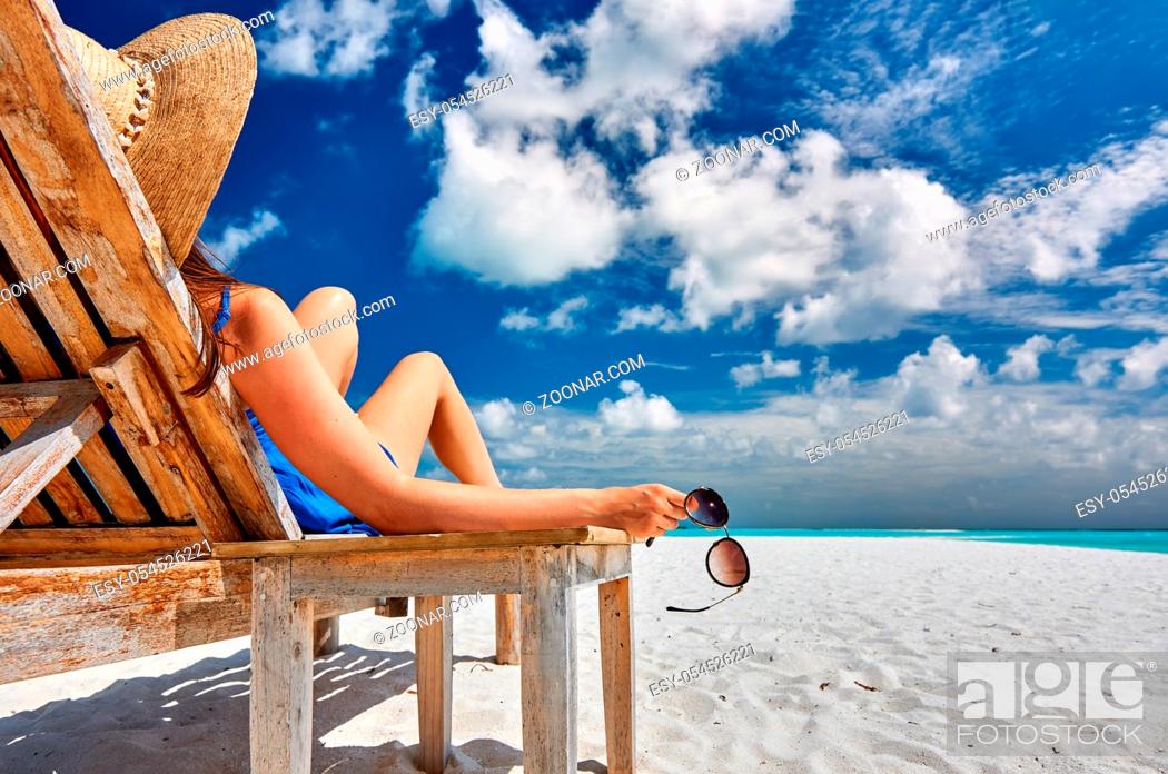 Stock Photo: Woman at beautiful beach holding sunglasses.