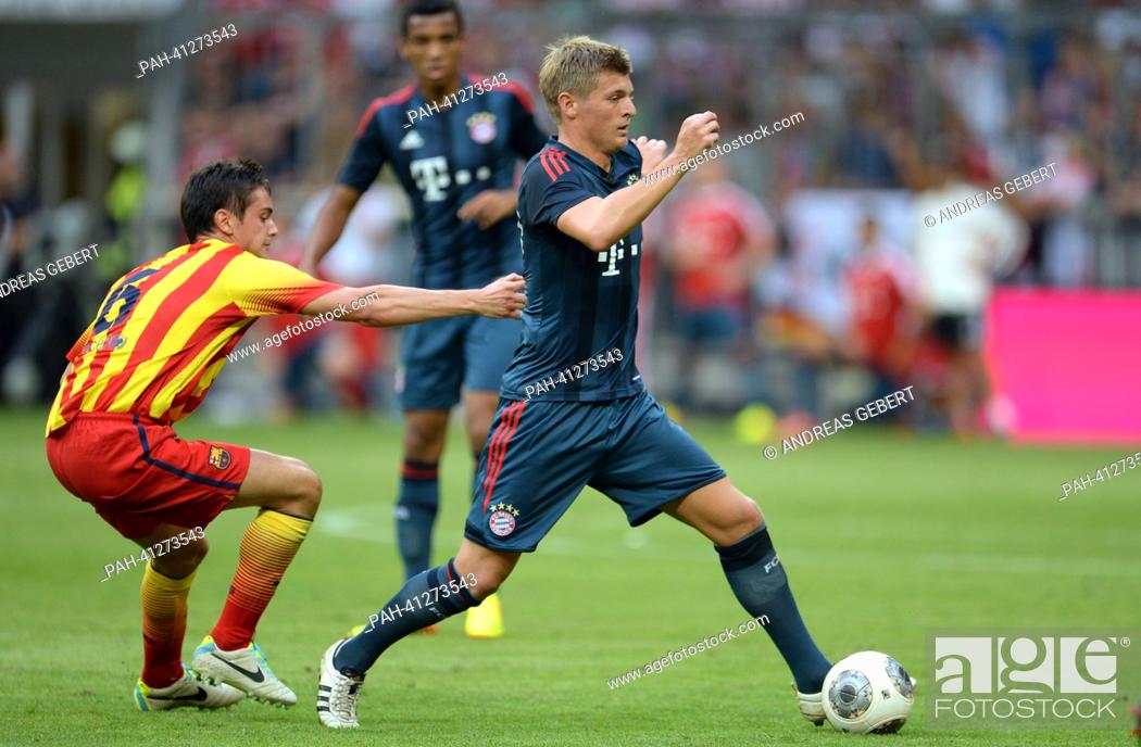 Stock Photo: Munich's Toni Kroos (R) and Barcelona's Jordi Quintilla vie for the ball the test match Uli Hoeness Cup FC Bayern Munich vs FC Barcelona at the Allianz Arena in.