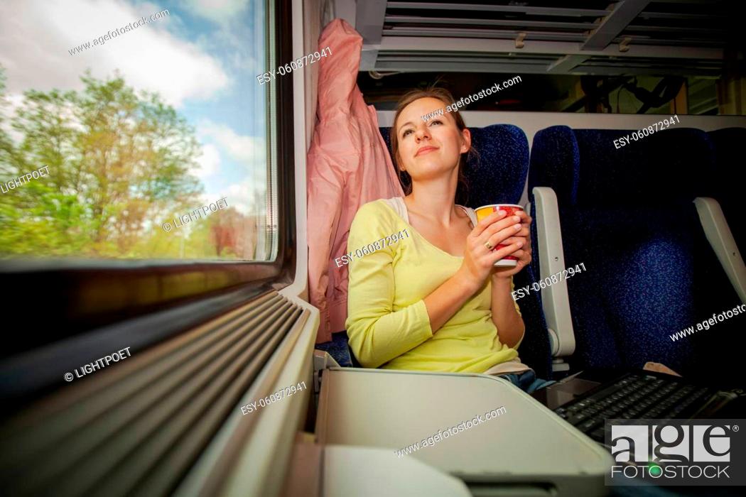 Stock Photo: Young woman traveling by train (landscape moving fast behind the window (<--- motin blurred image).