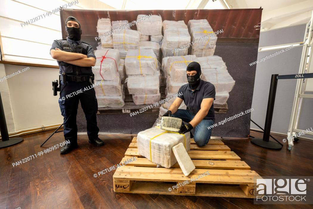 Stock Photo: 11 July 2022, Bavaria, Munich: A customs officer kneels in front of part of what has become the largest single seizure of cocaine in Bavaria to date.