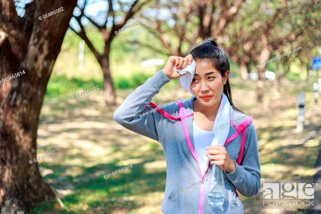 Stock Photo: young sporty woman resting and wiping her sweat with a towel after workout sport exercises outdoors at the park.