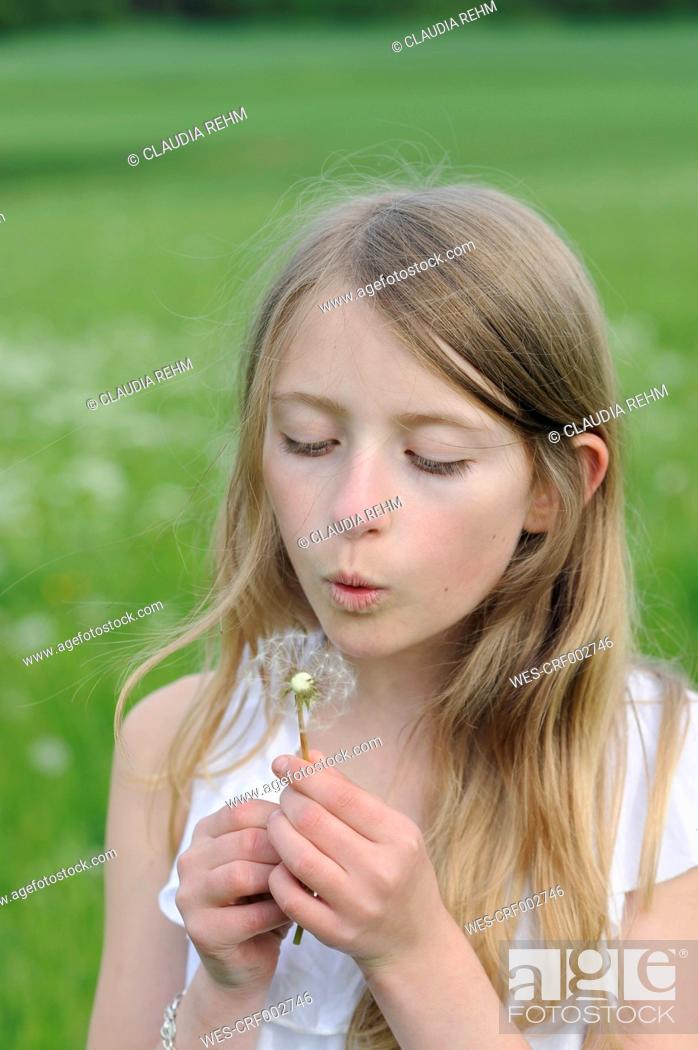 Stock Photo: Portrait of girl blowing blowball.