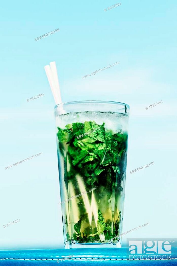 Stock Photo: One misted glass of cocktail mojito over blue sky background.