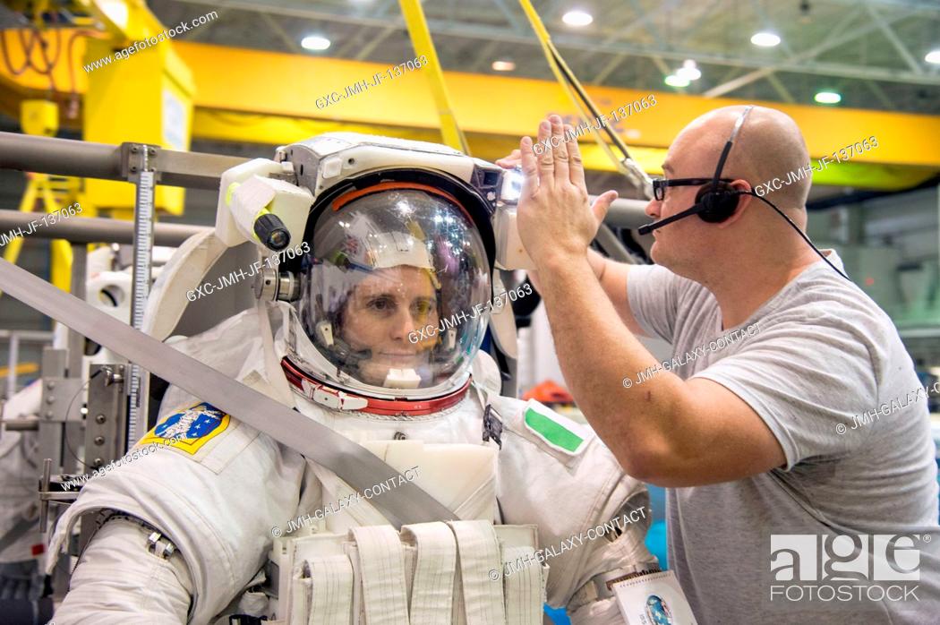 Stock Photo: European Space Agency astronaut Samantha Cristoforetti, Expedition 4243 flight engineer, gets help with final touches on a training version of her.