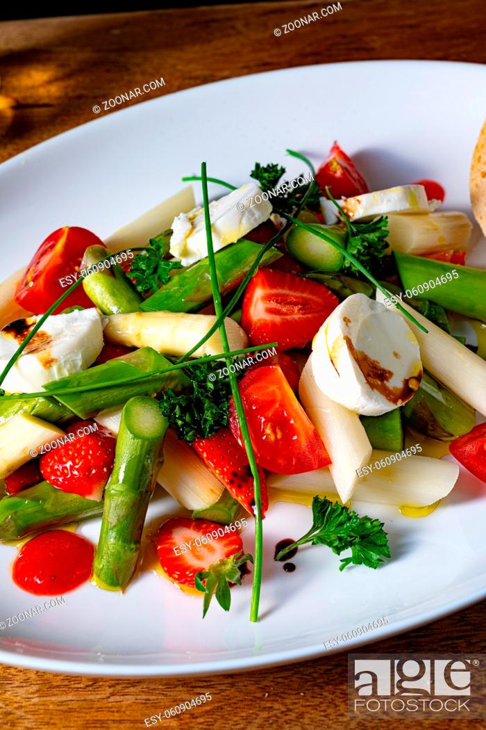 Stock Photo: Asparagus salad with strawberries, tomatoes and goat cheese.