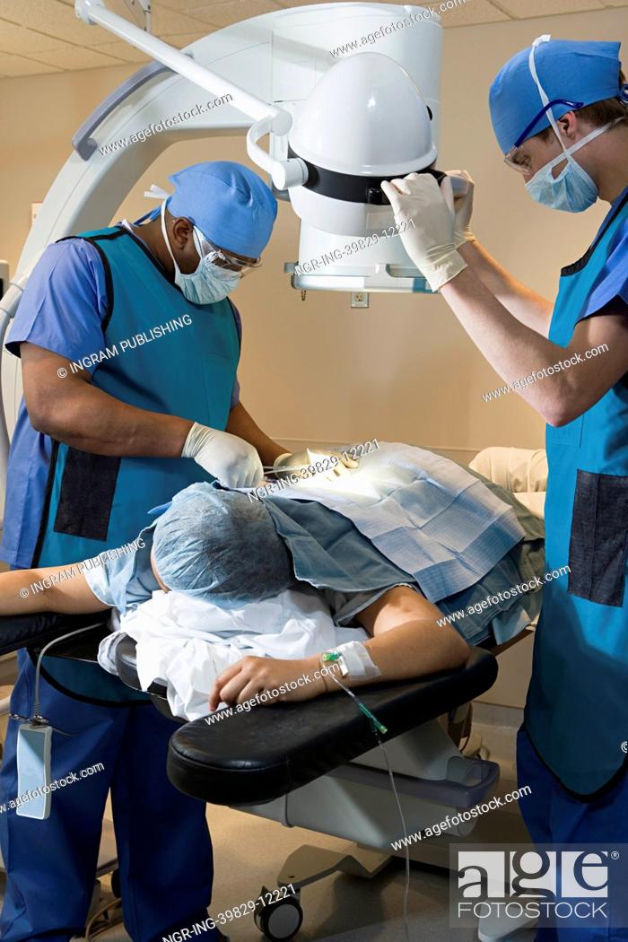 Stock Photo: Surgeons operating on patient.