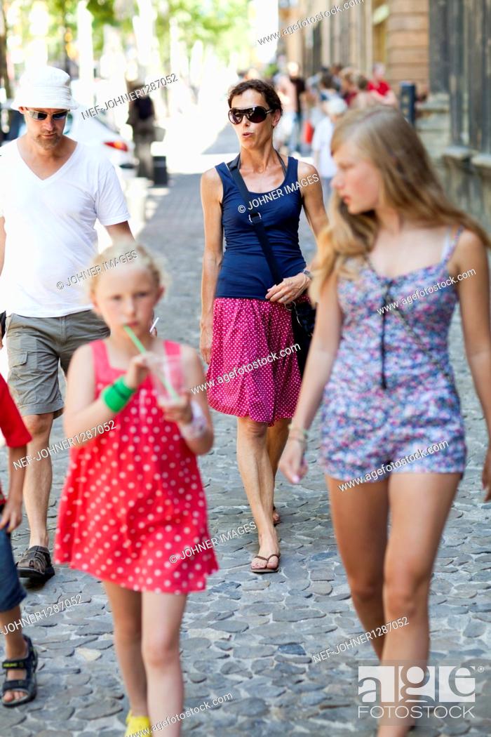 Stock Photo: Family walking on cobblestone walkway.