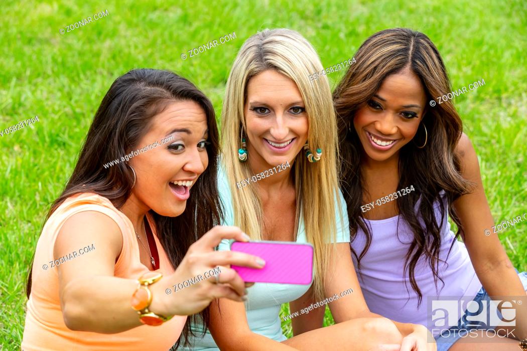 Photo de stock: Three young women take a group photo as they enjoy a day at the park.