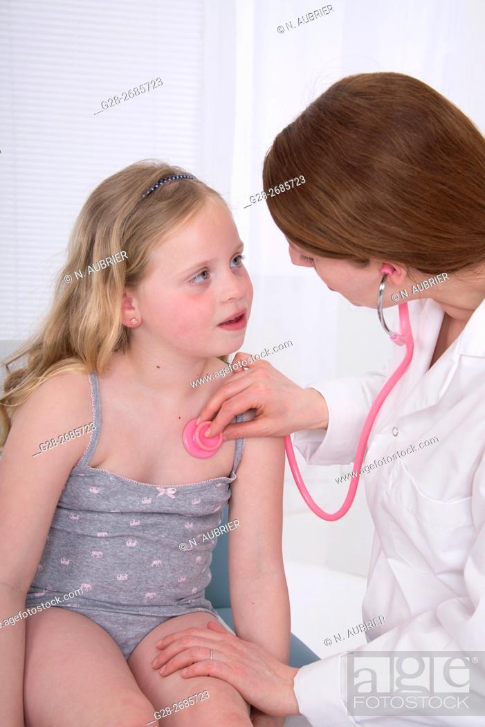 Stock Photo: Paediatrician doctor examining 6 year old little girl, with her stethoscope in surgery.