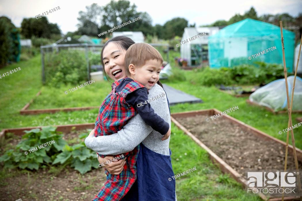 Stock Photo: Happy mother and toddler son in vegetable garden.