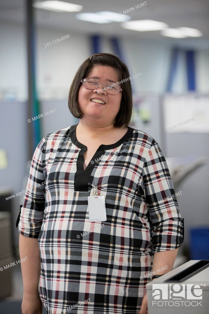 Stock Photo: Portrait of Asian woman with a Learning Disability working in an office.