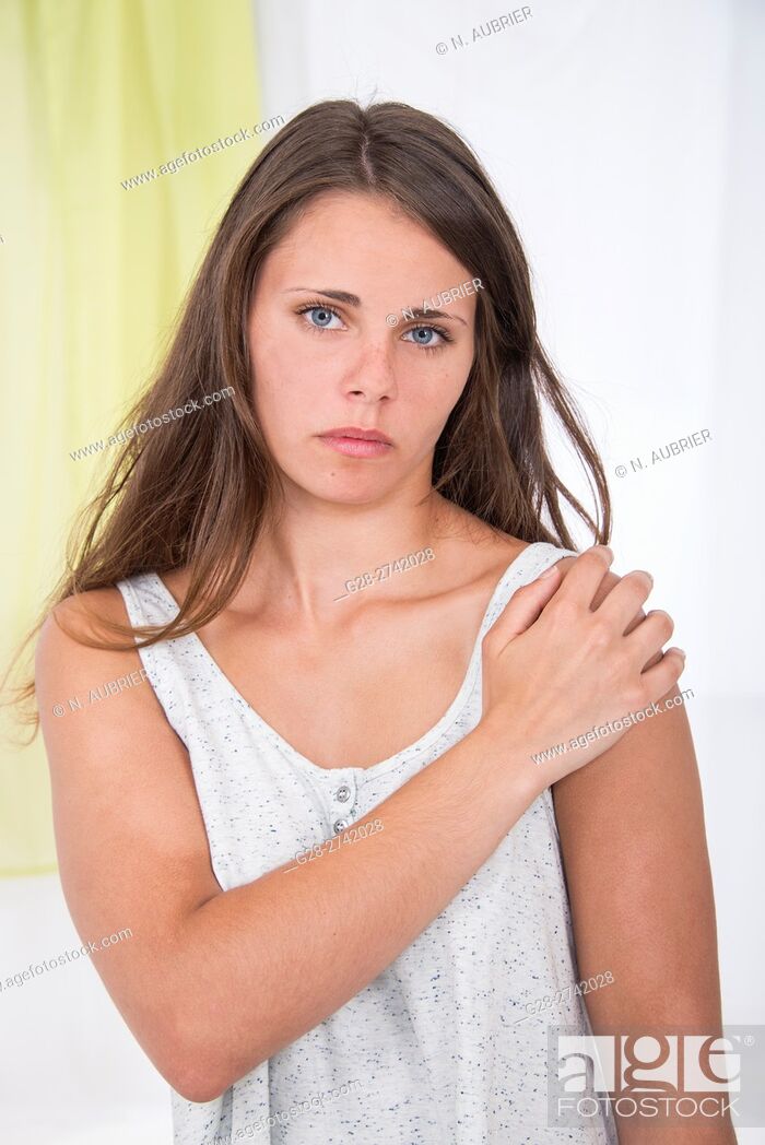 Stock Photo: Young woman holding her painful shoulder suffering from rheumatism.