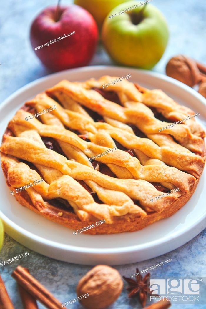 Stock Photo: Fresh and tasty sweet homemade apple pie cake with cinnamon sticks, walnuts and apples on side. Placed on stone background.