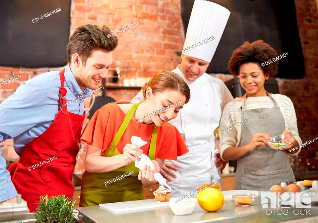 Stock Photo: cooking class, culinary, bakery, food and people concept - happy group of friends and male chef cook baking in kitchen.