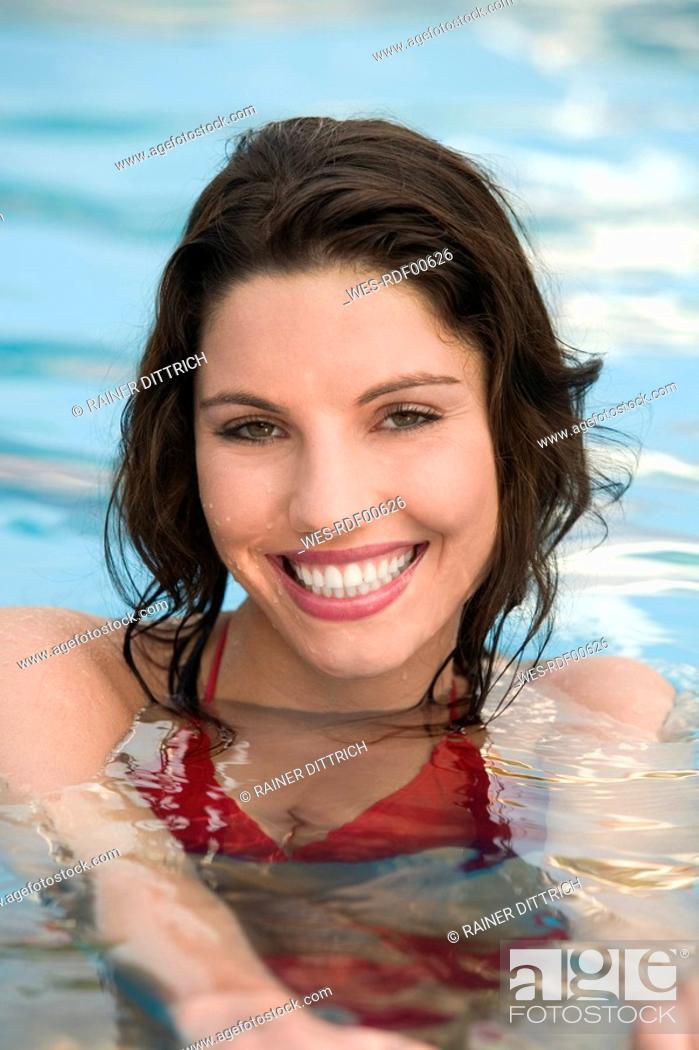 Stock Photo: Asia, Thailand, Young woman in pool, smiling, portrait.