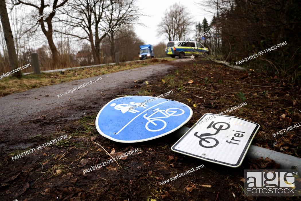 Stock Photo: 21 January 2021, Schleswig-Holstein, Neumünster: A buckled traffic sign lies on the ground at the scene of the accident next to the pedestrian and bicycle path.