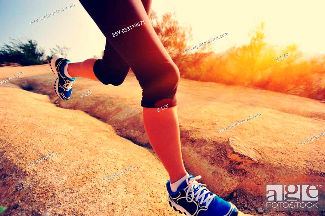 Stock Photo: young woman runner legs running on mountain trail.