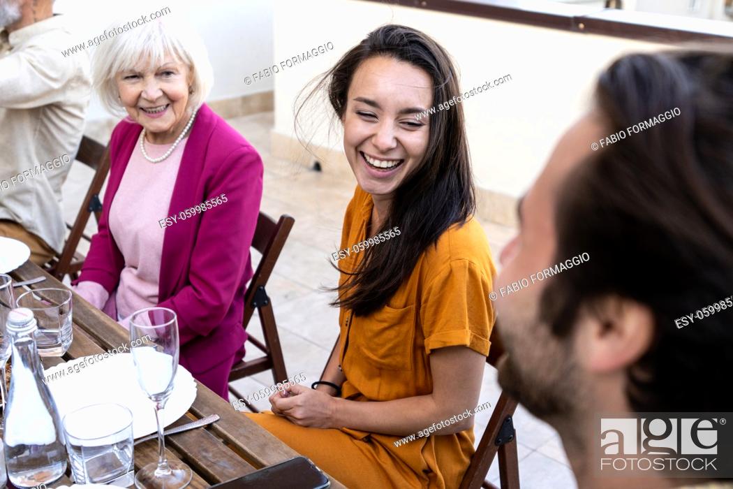 Stock Photo: Storytelling footage of a multiethnic group of people dining on a rooftop. Family and friends make a reunion at home.