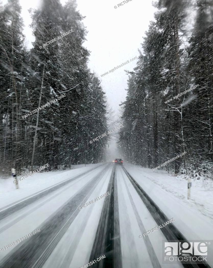 Stock Photo: 19 March 2021, Saxony, Rodewisch: Cars drive along a country road in heavy snowfall. With temperatures below freezing and snow showers.