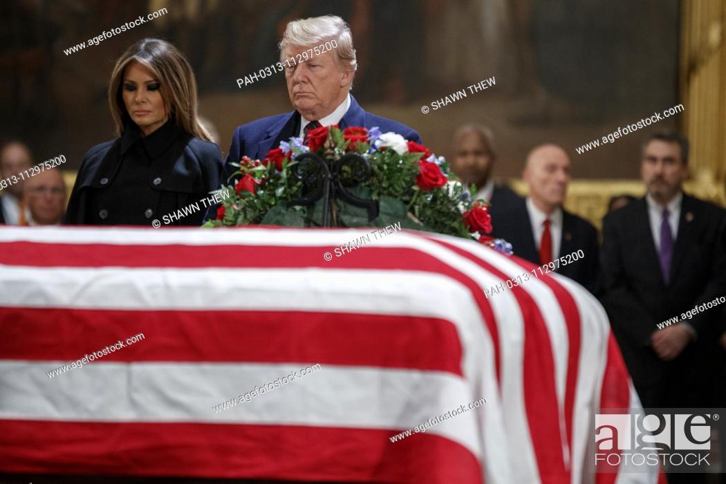 Stock Photo: US President Donald J. Trump and First Lady Melania Trump take a moment of silence at the casket containing the body of former US President George H.W.