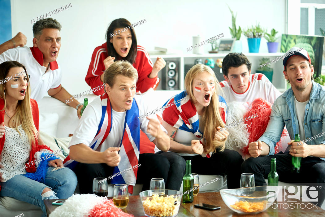Stock Photo: English soccer fans watching match together at home.