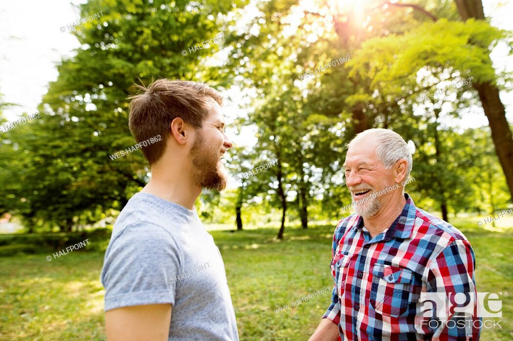 Stock Photo: Senior father and his adult son laughing together in a park.