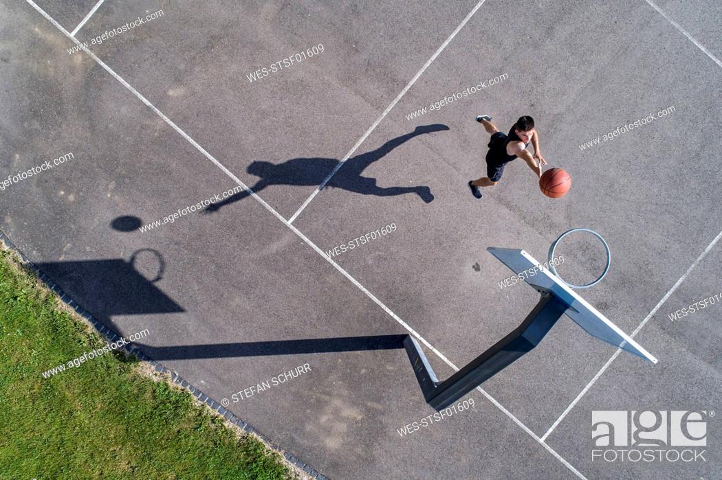 Stock Photo: Aerial view of young man playing basketball.