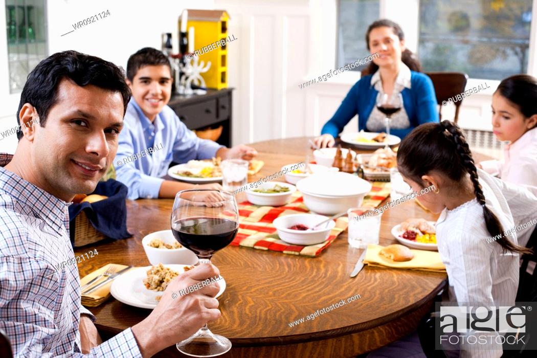 Stock Photo: Family at dinner table smiling.