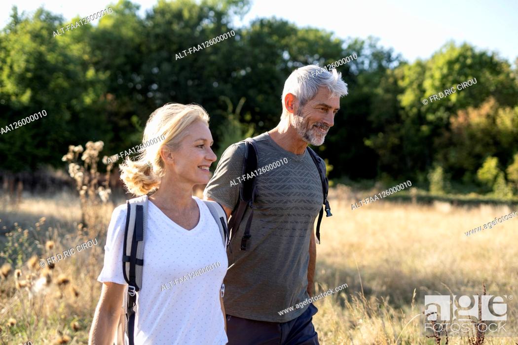 Stock Photo: Smiling mature couple hiking in forest.