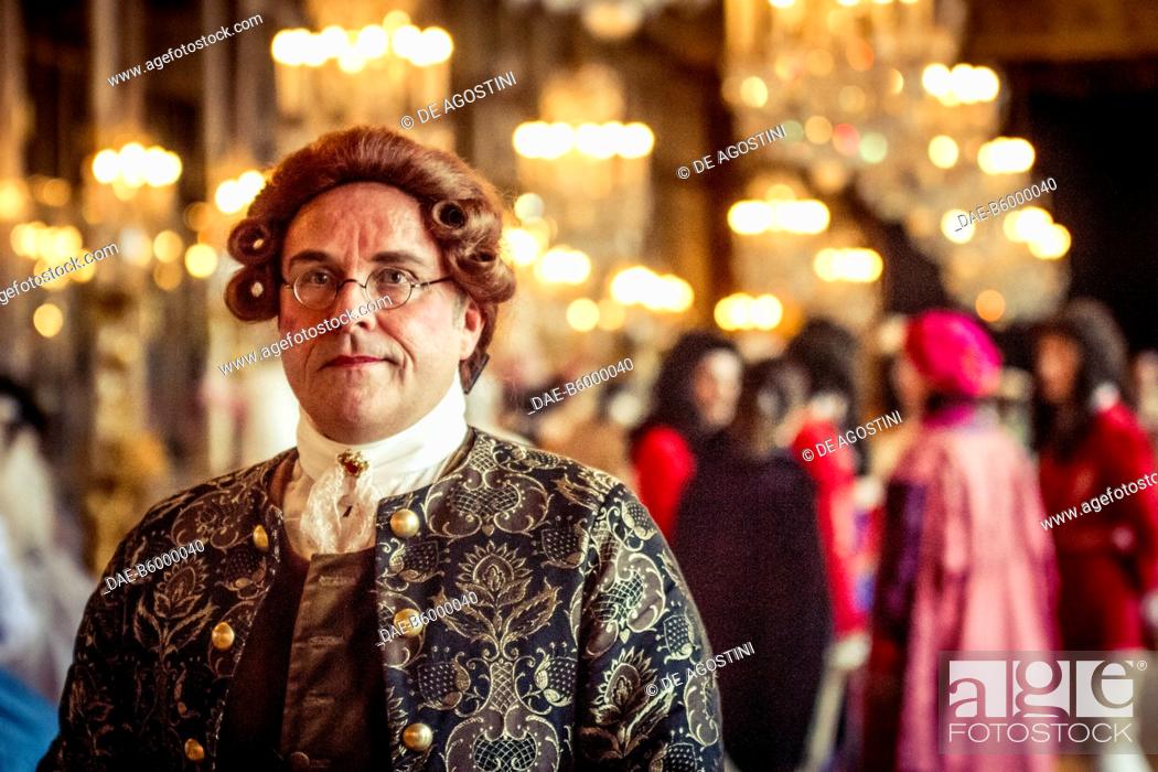 Stock Photo: A man wearing a wig and glasses in the Hall of Mirrors, courtship party (Fete galante) with participants wearing clothes from the Louis XIV period.