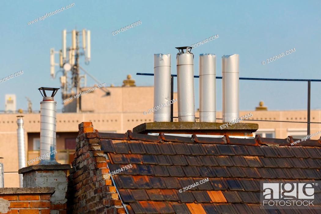 Stock Photo: Chimneys on roofs in late afternoon light.