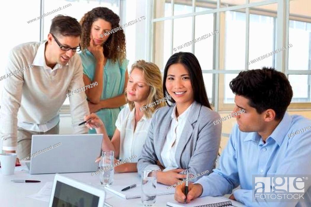 Stock Photo: Casual business team having a meeting using laptop.