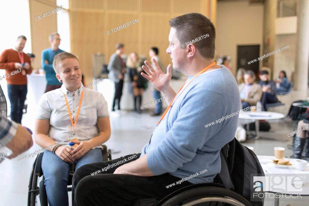 Stock Photo: Business people in wheelchairs talking at conference.