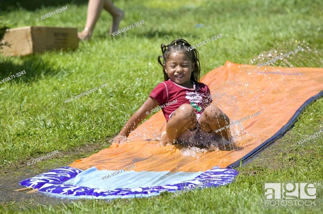 Imagen: Little boy sliding on a water slide in North Platte, Nebraska on a very hot summer day.