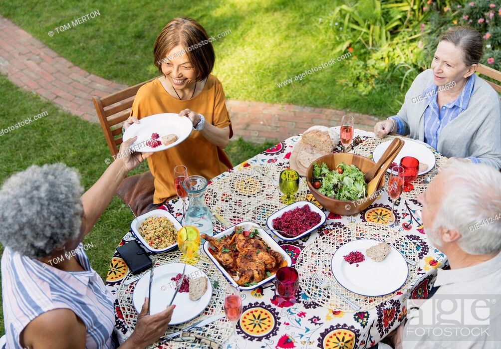 Stock Photo: Senior friends enjoying lunch at patio table.