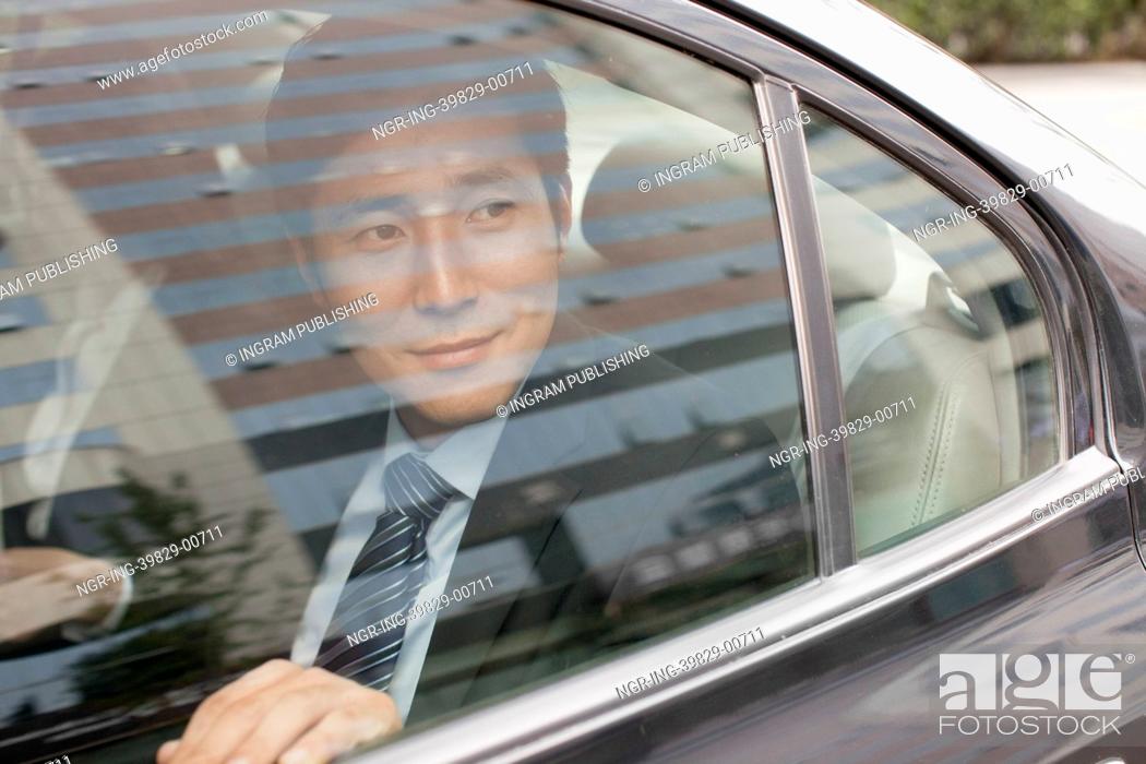 Stock Photo: Smiling Businessman in Car Back.