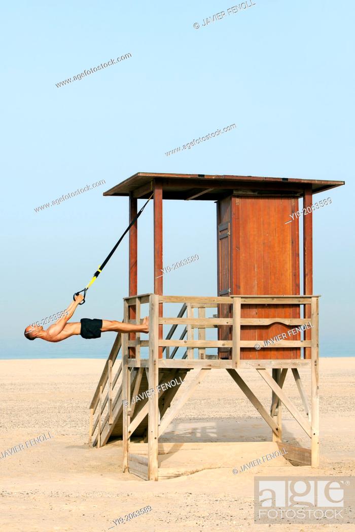 Stock Photo: man playing sports on the beach with trx.