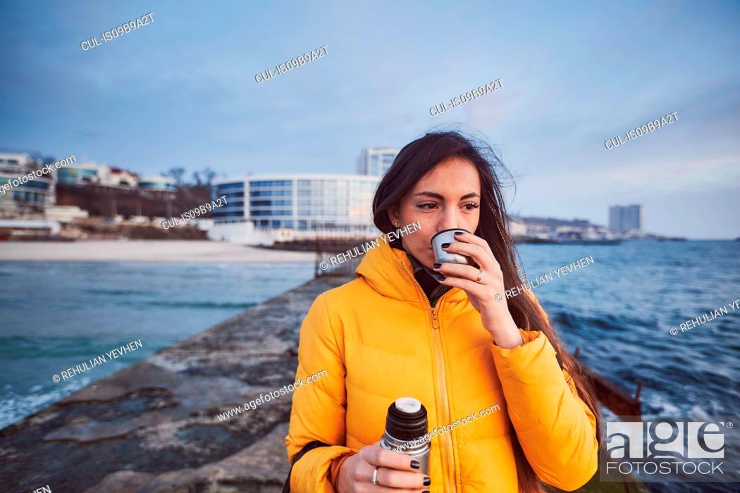 Stock Photo: Woman on pier drinking from flask, Odessa, Odessa Oblast, Ukraine, Europe.