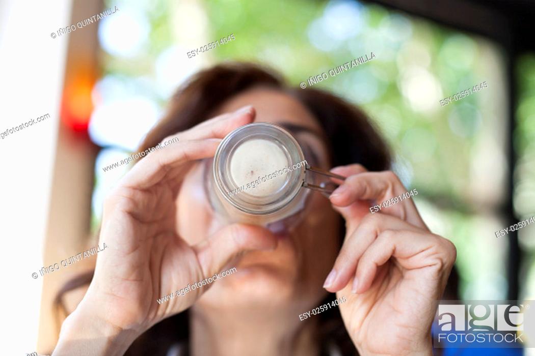 Stock Photo: portrait of woman drinking cappuccino coffee finishing cup in hands in cafe.