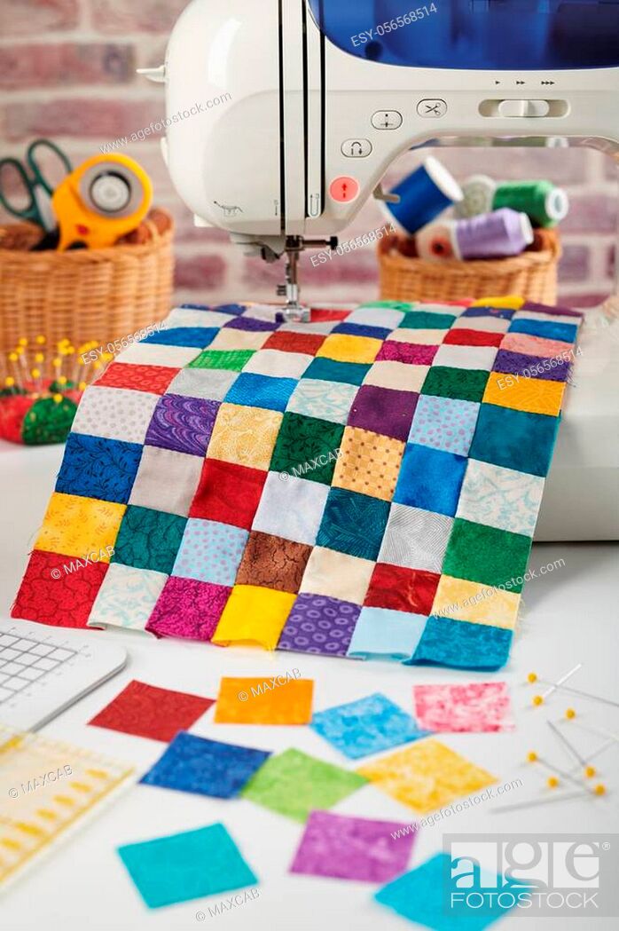 Stock Photo: Colorful detail of quilt sewn from square pieces on sewing machine, quilting and sewing accessories.