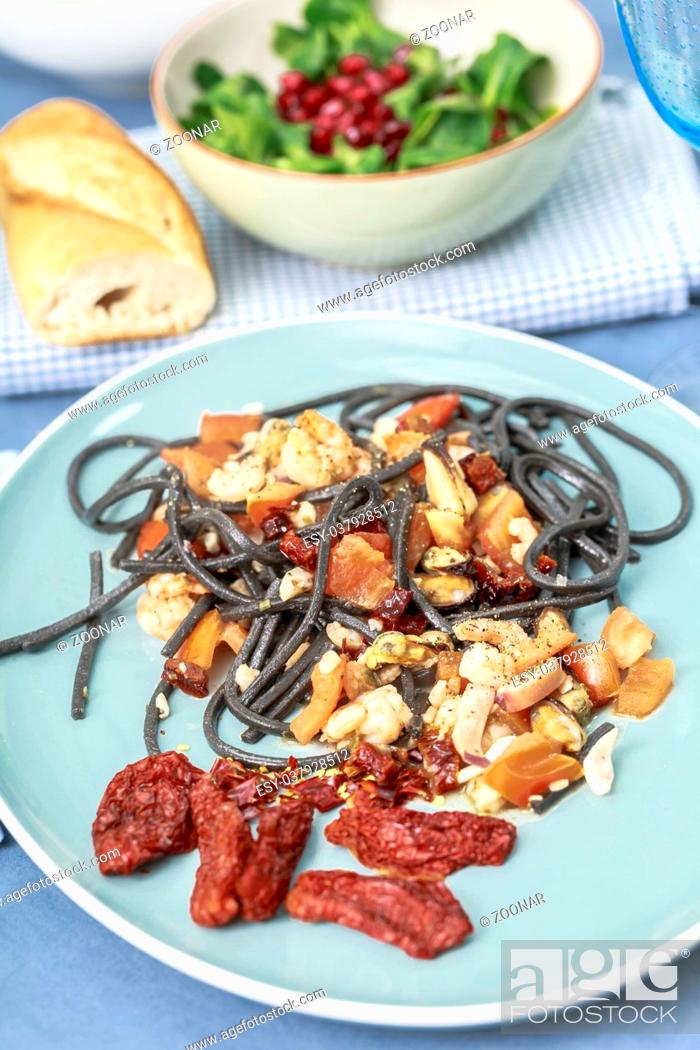 Stock Photo: Spaghetti with squid ink with seafood and tomatoes.